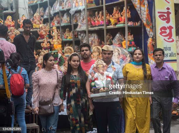 Family carries home an idol of Lord Ganesha on the eve of Ganesh Chaturthi, at Kasba Peth on August 30, 2022 in Pune, India.