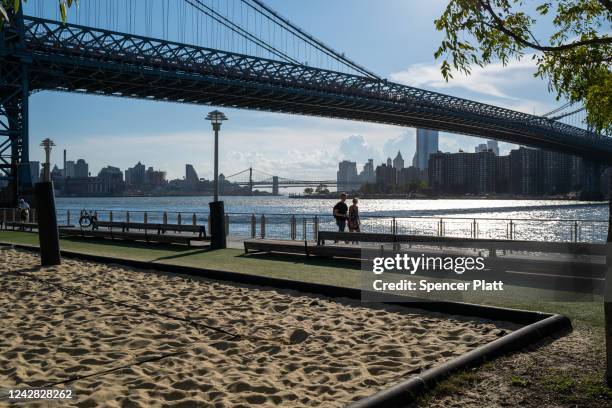 People enjoy the warm weather at Domino Park on August 30, 2022 in the Brooklyn borough of New York City. Temperatures are expected to remain high...