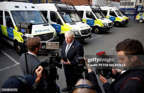 Britain's Prime Minister Boris Johnson, answers journalists' questions during a visit at a police station, in London, on August 31 as part of a tour...
