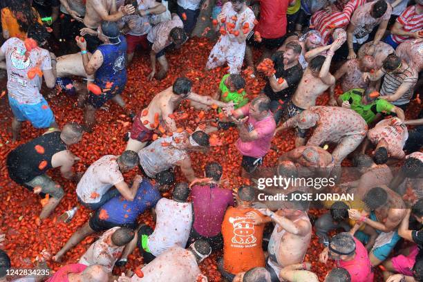 Revellers covered in tomato pulp take part in the annual "Tomatina" festival in the eastern town of Bunol, on August 31, 2022. - The iconic fiesta,...