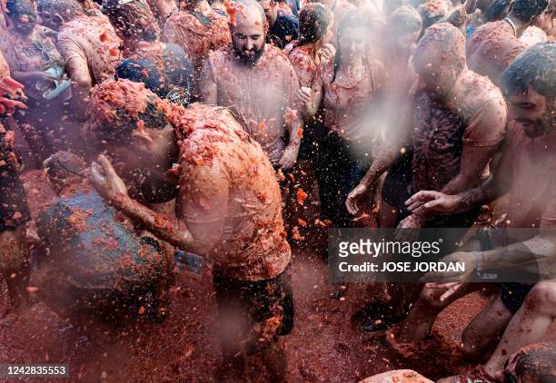 Revellers covered in tomato pulp take part in the annual "Tomatina" festival in the eastern town of Bunol, on August 31, 2022. - "La Tomatina", a...
