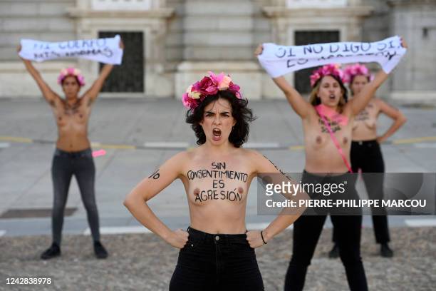 Member of the feminist activist group Femen with her bare chest reading "No consent is assault" protests with other activists in front of the Royal...