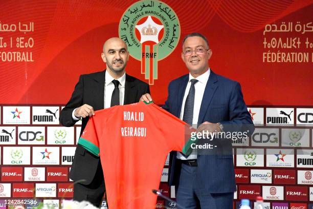 Moroccan coach Walid Regragui poses for a photo with Fouzi Lekjaa , President of Morocco's Royal Football Federation , and the national team jersey...