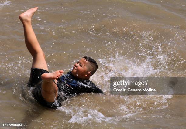 Julian Moreno, of Phoenix, Arizona, cools off in the surf on the first day of a heatwave in Santa Monica on August 31, 2022. We thought we could cool...