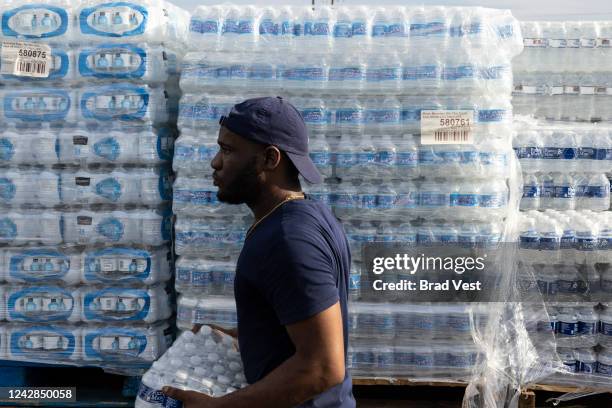 Jabari Omari, a City of Jackson employee, helps hand out cases of bottled water at a Mississippi Rapid Response Coalition distribution site on August...