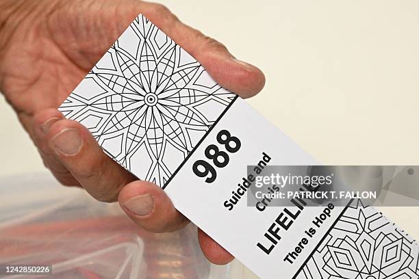 Bookmark for children with the 988 suicide and crisis lifeline emergency telephone number is displayed by Lance Neiberger, a volunteer with the...