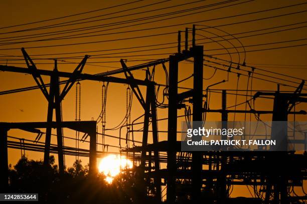 The sun sets behind electric power lines as the California Independent System Operator announced a statewide electricity Flex Alert urging...