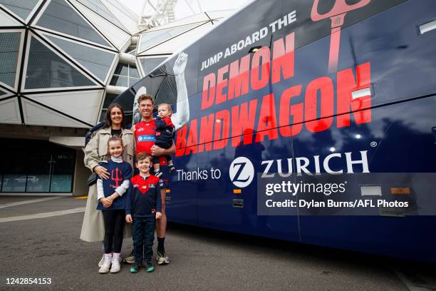 Jake Melksham of the Demons poses for a photo with his wife Stacey and children Frankie, Teddy and Alfie in front of the Melbourne Demons Bandwagon...