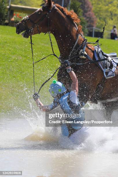 Alannah Dunstan of Great Britain falls at the Ice Pond water jump while competing on 'Jumping Star JWB' in the cross-country competition during the...