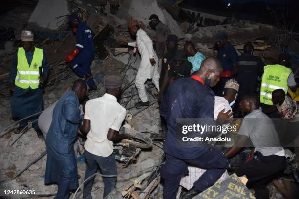 People conduct search and rescue operation at the site after a three-story building collapsed in northern Nigeriaâs commercial city of Kano on August...