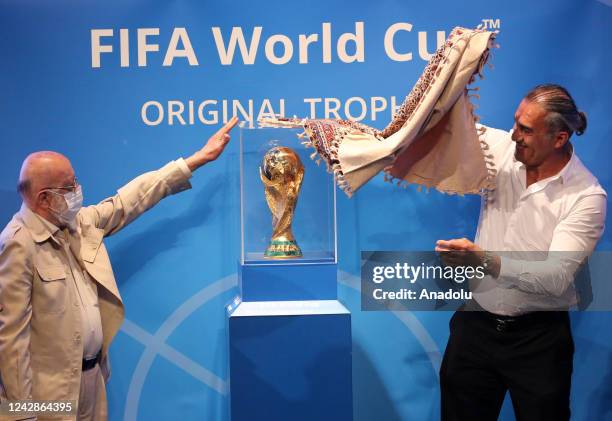 Former Iranian goalkeeper Ahmadreza Abedzadeh and head of the Tehran city council Mehdi Chamran unveil the FIFA World Cup Trophy at a hall in Milad...