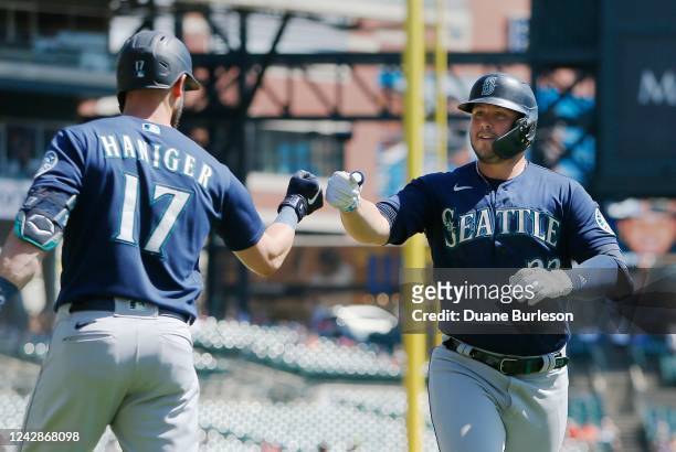 Ty France of the Seattle Mariners celebrates with Mitch Haniger after hitting a solo home run against the Detroit Tigers during the third inning at...