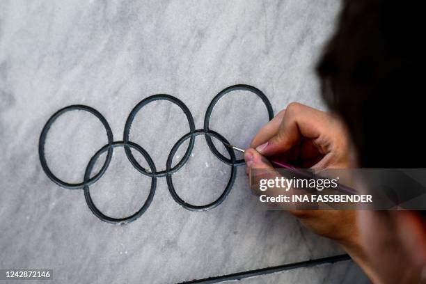 Man repaints the inscription of a commemorative plaque in front of an apartment building at Conollystrasse 31 at the former Olympic Village in...