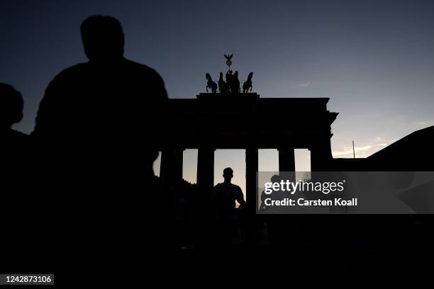 People walk among the Brandenburg Gate, one of Berlin's premiere landmarks, on the first day a new law to save energy nationwide has gone into effect...