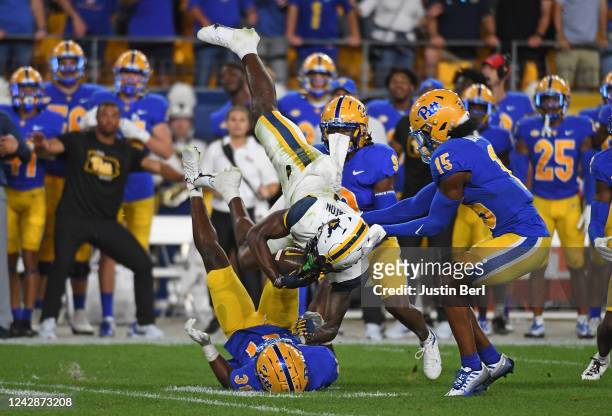 Bryce Ford-Wheaton of the West Virginia Mountaineers comes down with the ball for a catch between Pittsburgh Panthers defenders in the second quarter...