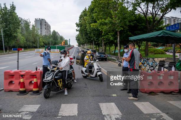 This photo taken on September 1, 2022 shows police officers checking information on a road amid restrictions due to an outbreak of the Covid-19...