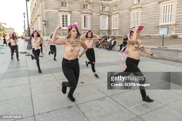 Topless members of the feminist activist group protest in front of the Royal Palace with slogans painted on their bodies against a wave of sexual...