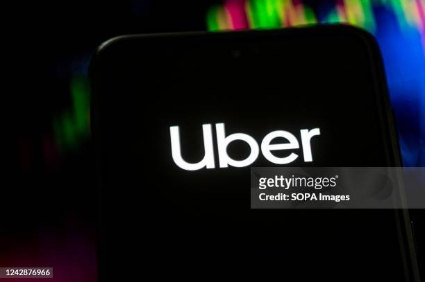 In this photo illustration a Uber logo seen displayed on a smartphone.