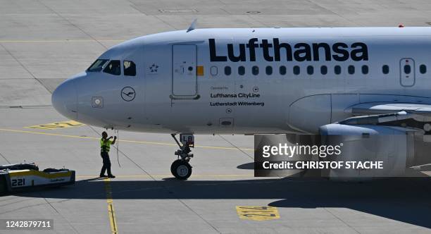 An employee prepares a Lufthansa plane for take-off at the Franz-Josef-Strauss airport in Munich, southern Germany, on September 2 as pilots called...