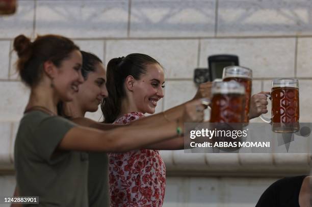 Visitors lift their pints on September 2 during the annual annual Oktoberfest beer festival in the village of Taybeh in the village of Taybeh, east...