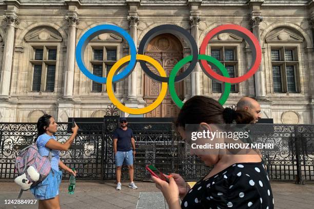 People walk past the Olympic Rings at the Hotel De Ville in Paris on September 2 the city that will host the 2024 Olympic and Paralympic Games.