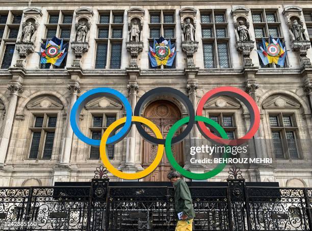 Man walks past the Olympic Rings at the Hotel De Ville in Paris on September 2 the city that will host the 2024 Olympic and Paralympic Games.