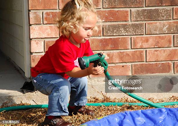 close-up of a girl holding a hose pipe - girl bums stock-fotos und bilder