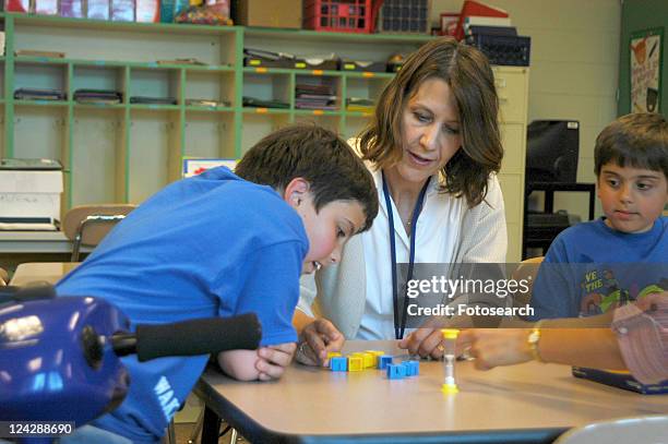 two brothers, both with muscular dystrophy, working with an occupational therapist on fine motor skills. - multiple sclerosis fotografías e imágenes de stock