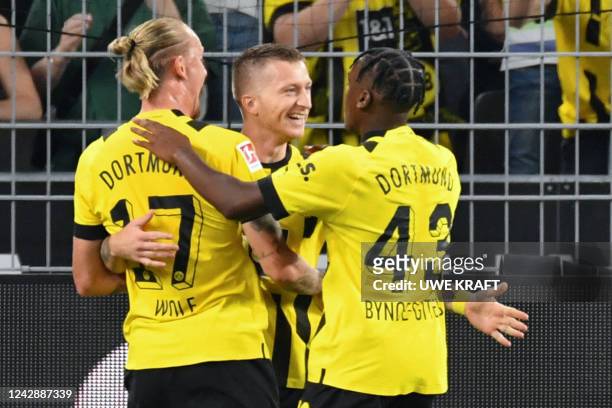 Dortmund's German forward Marco Reus celebrates after scoring a goal with Dortmunds German midfielder Marius Wolf and Dortmund's English forward...