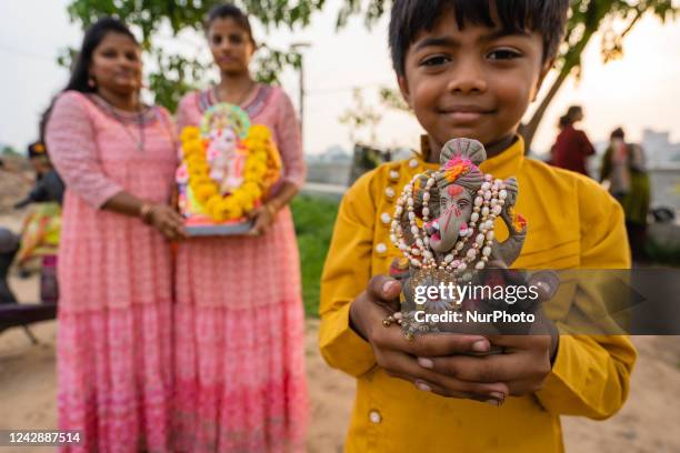 Hindus take part in a religious procession to immerse the idol of Lord Ganesha made of Plaster of Paris in an artificial pond to reduce water...