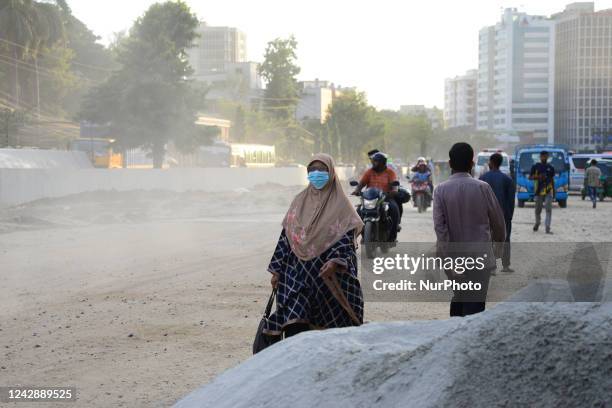 Peoples cross through a dusty busy road in Dhaka, Bangladesh, on September 2, 2022. The air condition of Dhaka city is worsening day by day at an...