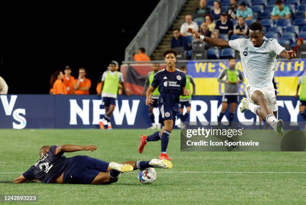 New England Revolution defender Andrew Farrell slide tackles the ball from Chicago Fire FC center forward Jhon Duran during a match between the New...