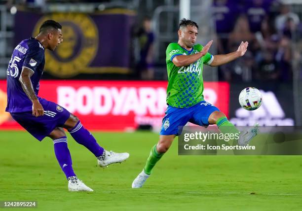 Orlando City defender Antônio Carlos passes the ball as Seattle Sounders midfielder Nicolás Lodeiro goes for the block during the MLS soccer match...