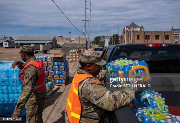 Member of the National Guard places a case of water in the back of a car at the State Fair Grounds in Jackson, Mississippi, on September 2, 2022. -...