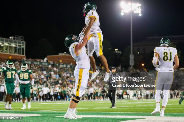 Malachi Imoh celebrates with Colby Sorsdal of the William & Mary Tribe after scoring a touchdown during a football game between the Charlotte 49ers...