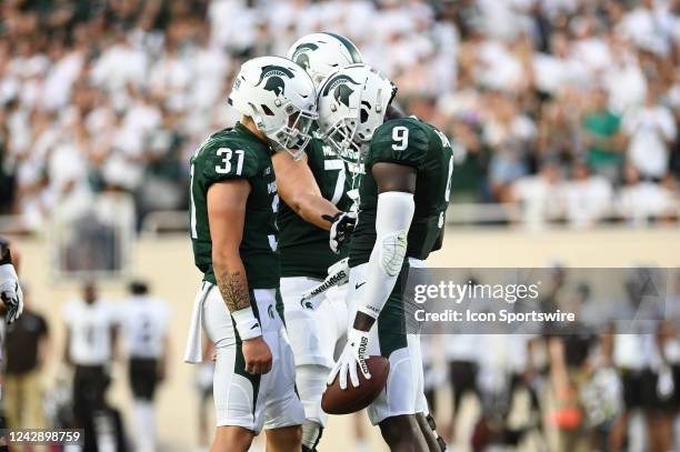 Michigan State Spartans tight end Daniel Barker celebrate his first half touchdown with Michigan State Spartans long snapper Hank Pepper during a...