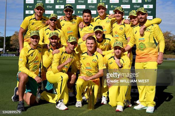 Australia's players pose with the trophy after a series win despite losing the third one-day international cricket match between Australia and...