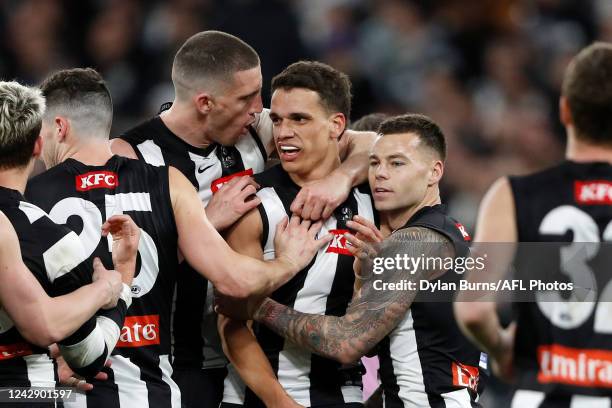 Ash Johnson of the Magpies celebrates a goal with Darcy Cameron and Jamie Elliott of the Magpies during the 2022 AFL First Qualifying Final match...