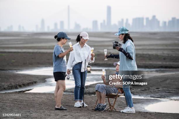 Four women take wine on the exposed banks due to low water levels caused by drought, along the Yangtze River. China has been hit by its most severe...