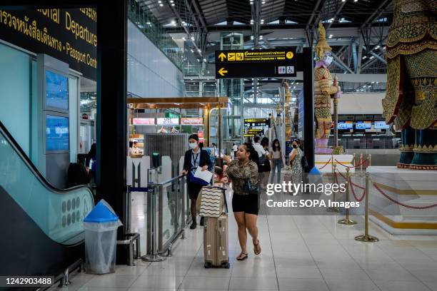 Traveler takes a photo of another departing passenger inside the international departures terminal at Suvarnabhumi International Airport ....