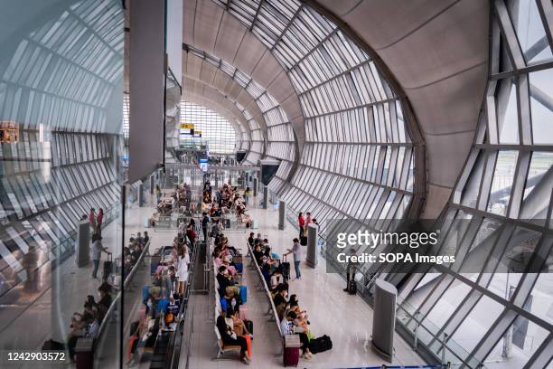 Passengers wait for a departing flight in the international departures hall at Suvarnabhumi International Airport . International tourism resumes at...