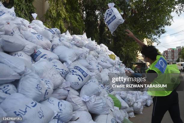 Volunteer of the Charity Al-Khidmat Foundation prepares relief bags for flood-affected people in Karachi on September 3, 2022. - Monsoon rains have...