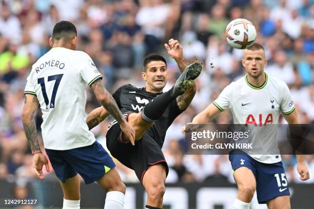 Fulham's Serbian striker Aleksandar Mitrovic vies with Tottenham Hotspur's Argentinian defender Cristian Romero and Tottenham Hotspur's English...