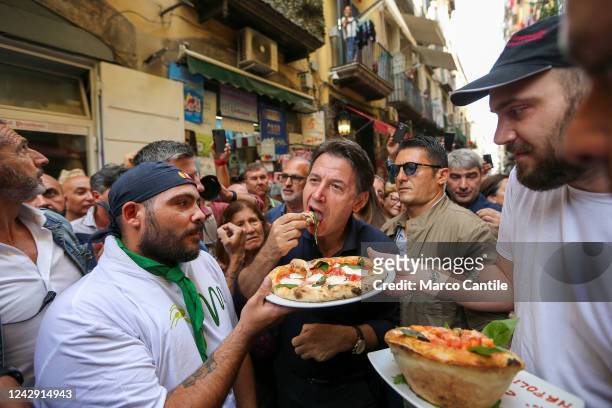 The political leader of the Five Stars Movement, Giuseppe Conte, eats a pizza offered by a pizza chef during the electoral tour in Naples, in the...