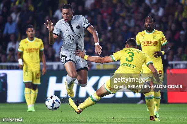 Paris Saint-Germain's French forward Kylian Mbappe fights for the ball with Nantes' Brazilian midfielder Andrei Girotto during the French L1 football...