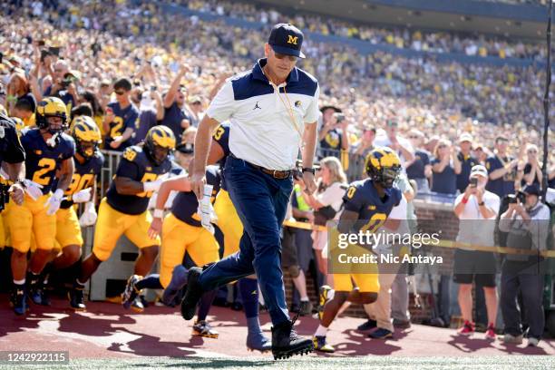 Head coach Jim Harbaugh of the Michigan Wolverines takes the field with his players before the first half against the Colorado State Rams at Michigan...