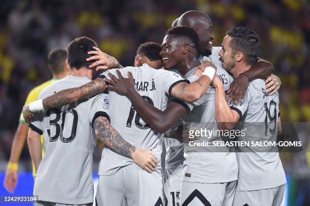Paris Saint-Germain's Portuguese defender Nuno Mendes celebrates with teammates after scoring his team's third goal during the French L1 football...