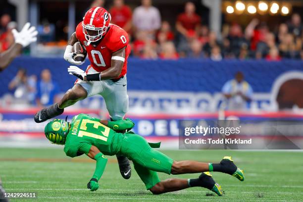 Darnell Washington of the Georgia Bulldogs is tackled by Bryan Addison of the Oregon Ducks during the first half at Mercedes-Benz Stadium on...