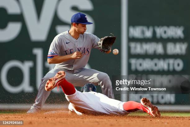 Xander Bogaerts of the Boston Red Sox slides headfirst into second base with a double as Corey Seager of the Texas Rangers gets the throw during the...