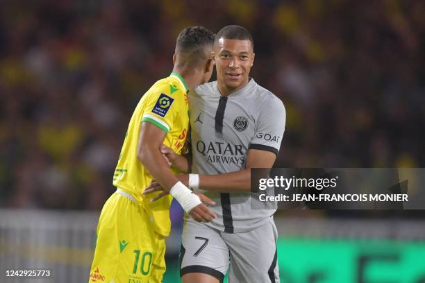 Paris Saint-Germain's French forward Kylian Mbappe and Nantes' French midfielder Ludovic Blas react during the French L1 football match between FC...